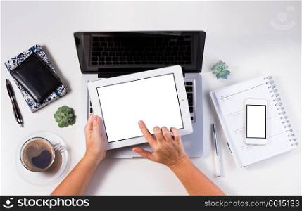 Styled workspace with laptop, phone and and hand holding tablet, flat lay top view scene. Styled workspace with laptop