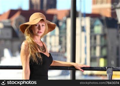 Stylish autumn traveler woman in hat outdoors in european city, old town Gdansk in the background, Poland Europe
