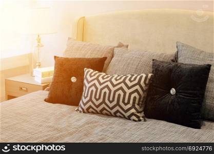 stylish bedroom interior design with black patterned pillows on bed and decorative table lamp.