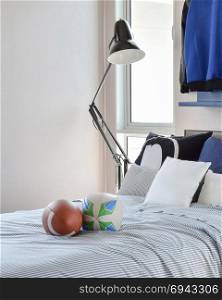 stylish bedroom interior design with blue patterned pillows on bed and decorative table lamp.
