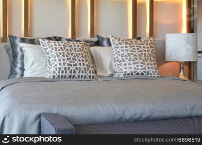 stylish bedroom interior design with brown pillows on bed and decorative table lamp.