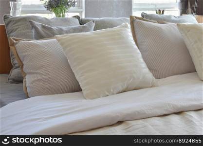 stylish bedroom interior design with white striped pillows on bed