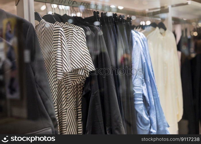 stylish blouses clothes hang on hangers in a store in a mall