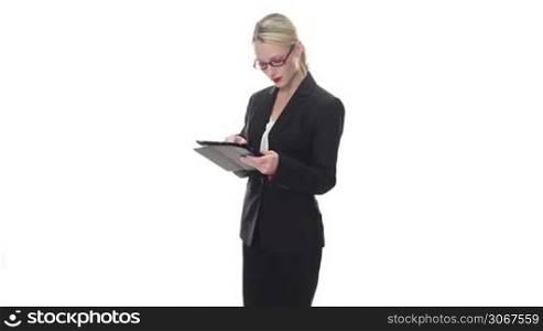 Stylish businesswoman wearing glasses standing smiling at the camera holding a tablet computer in her hands isolated on white