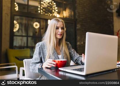 stylish businesswoman with laptop cosy coffee shop