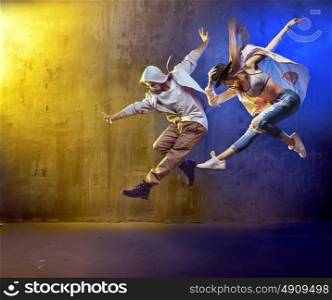Stylish dancers fancing in a concrete place