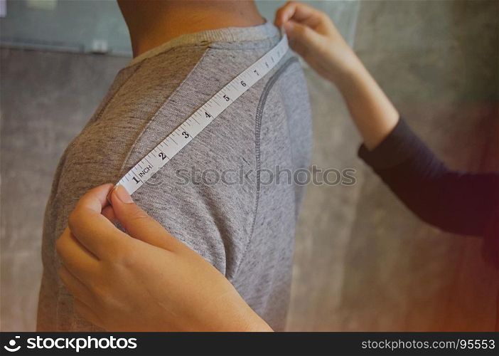 Stylish Fashion Designer measuring back width of client in atelier. Creative Design Concept