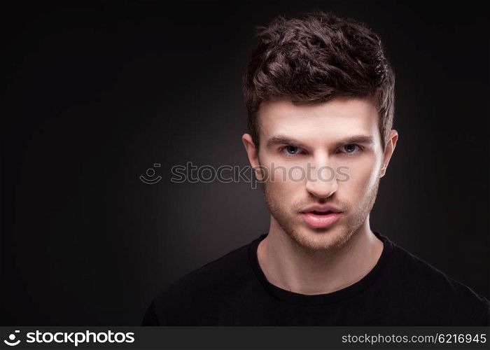 Stylish guy close up portrait on black background