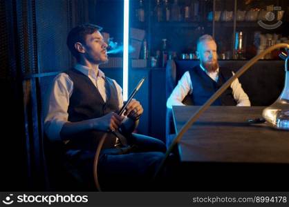 Stylish guys smoking hookah in bar while talking. Concept of having good time and nice conversation. Stylish guys smoking hookah in bar while talking