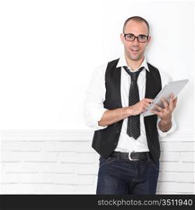 Stylish handsome guy leaning on wall with touchpad