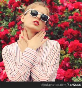 Stylish hipster girl in trendy glasses. Glamorous photo shoot in a chic outdoor garden. Photo toned style Instagram filters