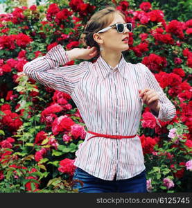 Stylish hipster girl in trendy glasses. Glamorous photo shoot in a chic outdoor garden. Photo toned style Instagram filters