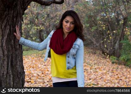 Stylish Hispanic woman posing outdoors during fall