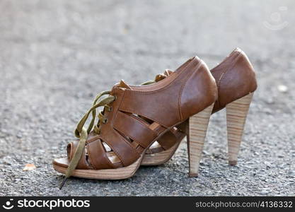 Stylish leather women shoes with laces on asphalt background