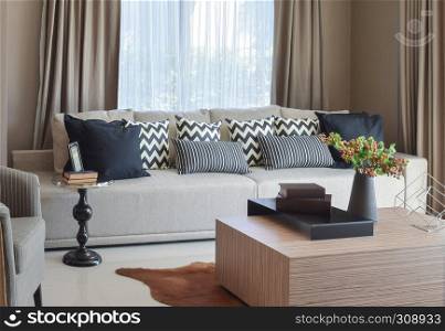 stylish living room design with grey striped pillows on comfortable sofa