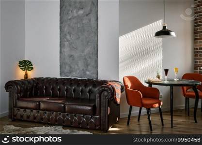 Stylish loft-style living and dining area with ebony table and red armchairs. Sunshine morning light from the window illuminates the room through the blinds. Retro style, leather sofa and carpet.