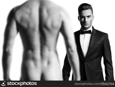 Stylish man in black suit in front of nude atletic male model