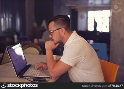 Stylish Man using laptop in startup office