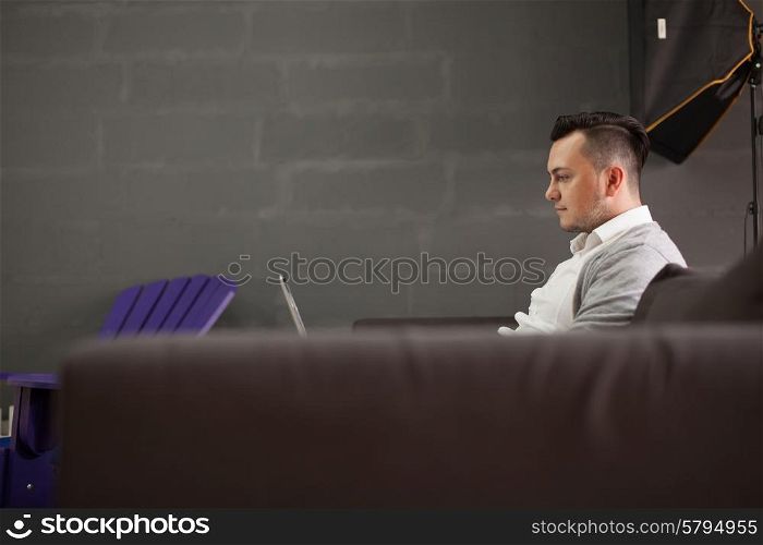 Stylish Man using laptop in startup office