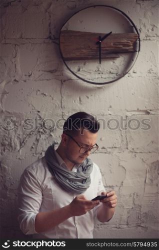 Stylish man using smartphone in startup office