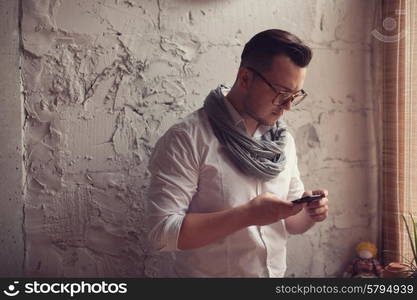 Stylish man using smartphone in startup office