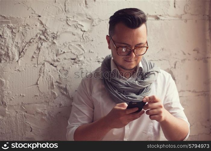 Stylish man using smartphone in startup office
