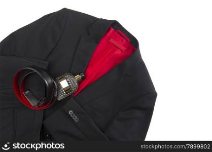 Stylish mens black or dark grey jacket with a colorful crimson lining and matching leather belt lying on a white background with a glass toiletry bottle, overhead view with copyspace