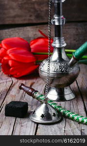 Stylish metal Arabic shisha and a bunch of tulips. Stylish Arabic hookah