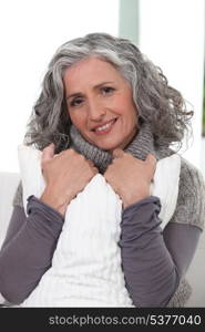 Stylish older woman holding a pillow