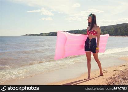 Stylish pinup girl posing with swimming mattress