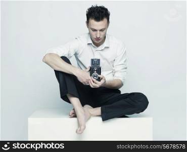 Stylish portrait of a young man with a camera