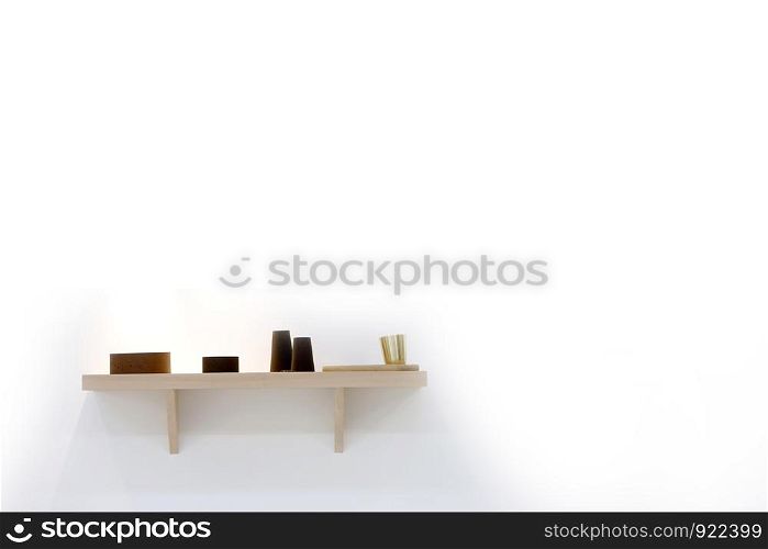 Stylish shelf with various dishware hanging on white wall. Decorative vases on wooden shelf