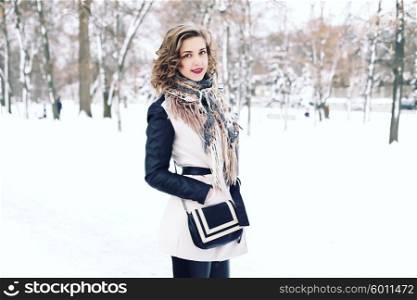 stylish street fashion concept - young slim blond woman with purple lips and curly hair posing in the street in winter. hair care, fashion bob hairstyle. hipster girl outdoors