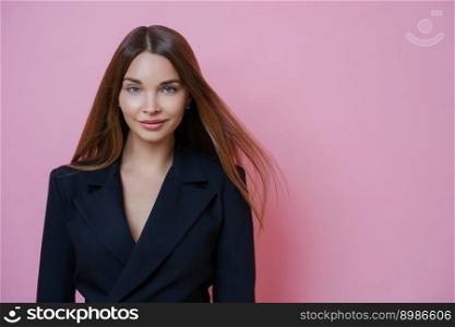 Stylish successful brunette European woman employee dressed in black formal outfit, ready to start own business, stands confident indoor, isolated on pink background. People, profession, occupation