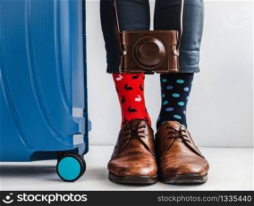 Stylish suitcase, men&rsquo;s legs, multicolored socks and new shoes on a white, isolated background. Close-up, indoors. Studio foto. Concept of style, fashion, beauty and vacation. Young kitty lying on a window sill