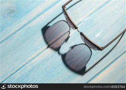 stylish sunglasses on table. stylish sunglasses on blue wooden table with sunlight