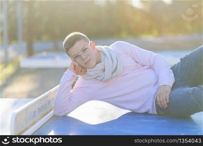Stylish teenager lying on a table tennis in a city park