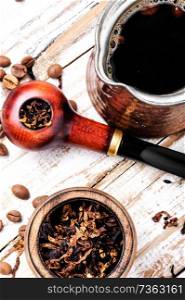 Stylish tobacco pipe with tobacco and brewed coffee. Smoking pipe and coffee