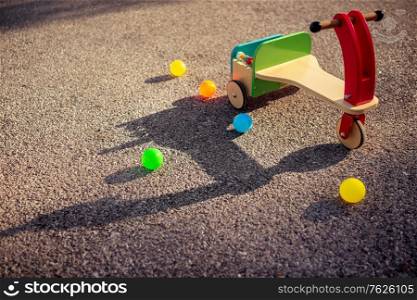 Stylish vintage wooden colorful bicycle and many little balls on the asphalt, outdoors amusement for kids, happy childhood concept