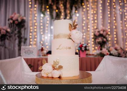 Stylish wedding cake with leaves.. An original high wedding cake decorated with flowers and leaves 3813.