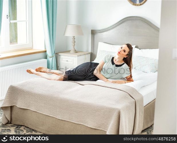 Stylish woman lying in the fancy bedroom