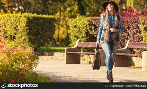 Stylish woman on air. Female fashion. Attractive long haired model wearing stylish clothes walking in park. Fashionable young model spending time on air.