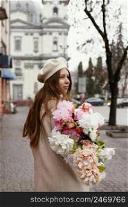 stylish woman outdoors holding bouquet flowers spring