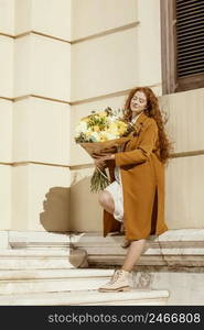 stylish woman outdoors with bouquet spring flowers