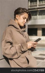 stylish woman wearing sportswear while checking her phone