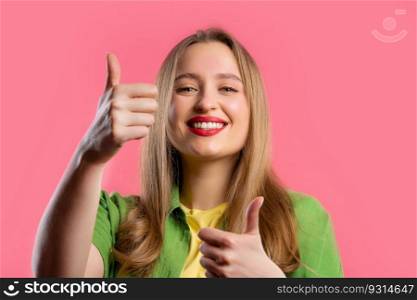 Stylish woman with hand sign like, thumbs up gesture. Happy lady, correct perfect choice, great deal, pink background. Positive female model smiles to camera, approval, trust concept. quality. Stylish woman with hand sign like, thumbs up gesture. Lady on pink background