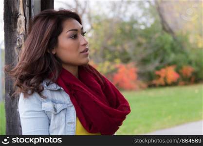 Stylish woman with red scarf posing outdoors on an autumn day