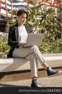 stylish woman working laptop outdoors