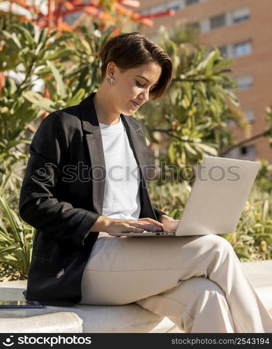 stylish woman working laptop outside