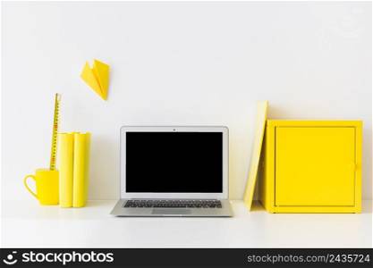 stylish workspace with laptop yellow metal box